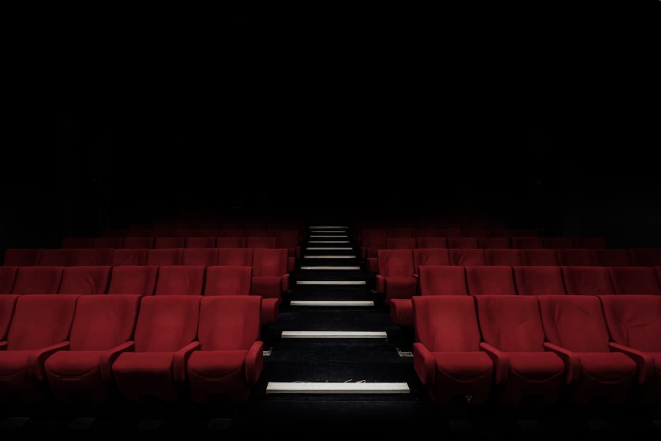 The darkened auditorium of The Gull, rows of deep red velvet seats lit by aisle lights